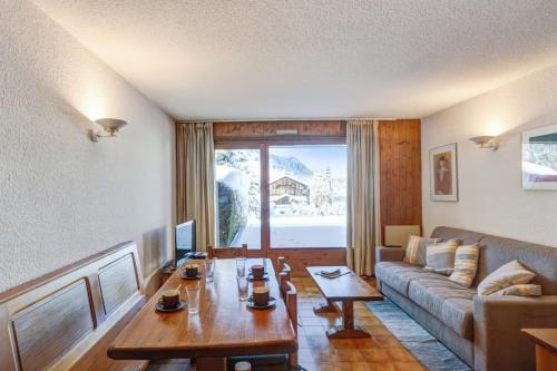 un salon avec une table et un canapé dans l'établissement Apartment with garden on the snow front, à Megève