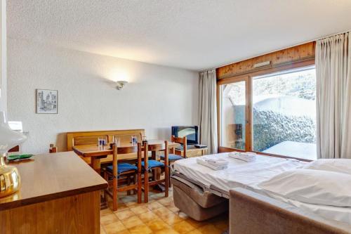 une chambre d'hôtel avec un lit, une table et des chaises dans l'établissement Apartment with garden on the snow front, à Megève