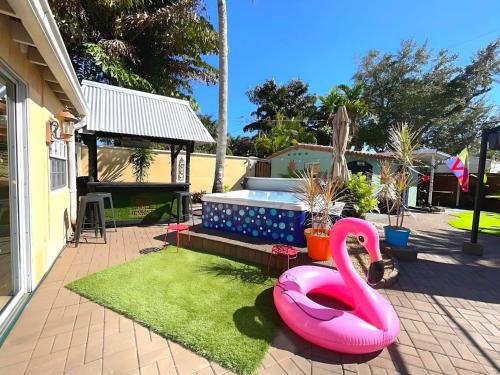 a pink flamingo in the yard of a house at Fun Getaway: Hot Tub, Tiki Bar, Arcade Room in Hollywood
