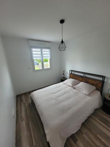 Un dormitorio con una gran cama blanca con ventana. en La Bohème, en Guilmécourt
