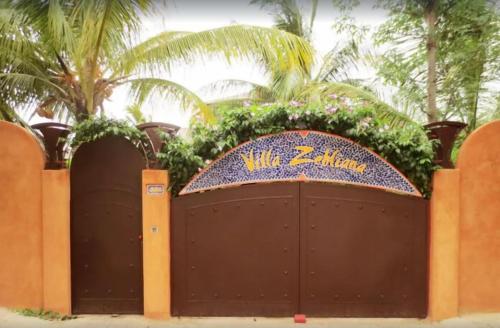 a gate at a resort with a sign on it at Villa Zehliana in Saly Portudal