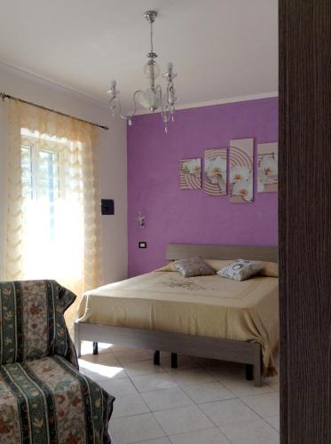 a bedroom with a bed and a purple wall at B&B Peschici Rooms in Peschici