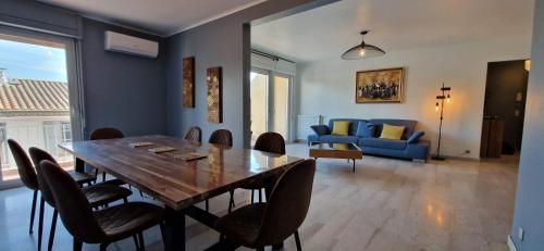une salle à manger avec une table, des chaises et un canapé dans l'établissement T4 Rare dans le centre d'Aix,terrace, parking, elevator, à Aix-en-Provence