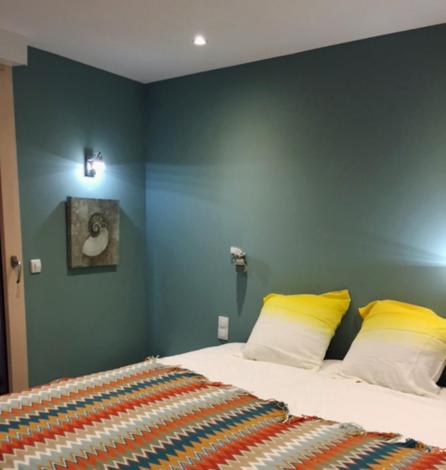 - une chambre avec un lit et 2 oreillers jaunes dans l'établissement Ecréhous - Chambre dans Embruns, à Barneville-Carteret