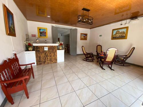 a living room with chairs and a table in it at Hostal Pochote in León