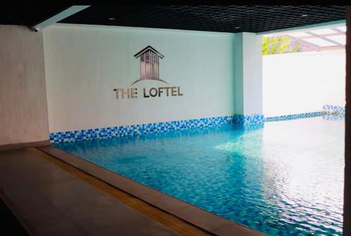 RuakaにあるModern Studio at the Loftel by Nyvin Homesのホテルの看板が壁に貼られたスイミングプール