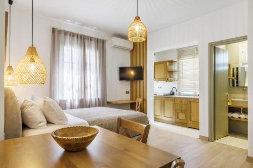 a room with a bed and a table and a kitchen at Skopelos Prime Central Stays in Skopelos Town