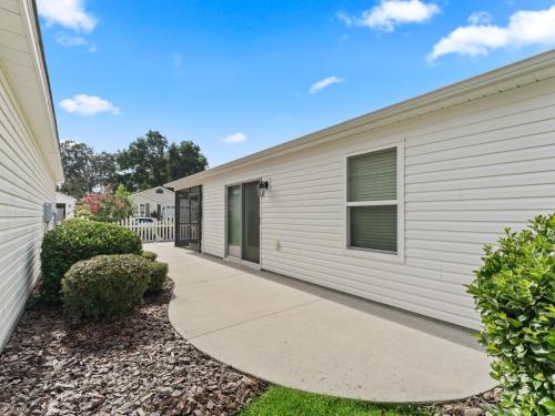 a white house with a sidewalk next to it at 5682 Z6 VILLAGE OF DESOTO by REMAX Premier in The Villages