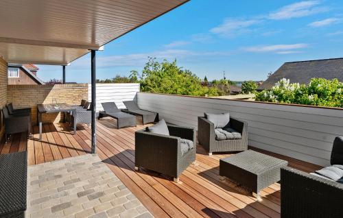 a patio with chairs and tables on a wooden deck at 3 Bedroom Awesome Home In Kalvehave in Kalvehave