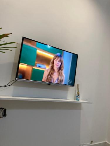 a flat screen tv sitting on top of a shelf at Apto aconchegante pertinho da praia in Guarujá
