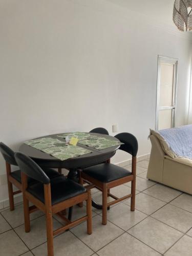 a table and chairs in a room with a bed at Apto aconchegante pertinho da praia in Guarujá