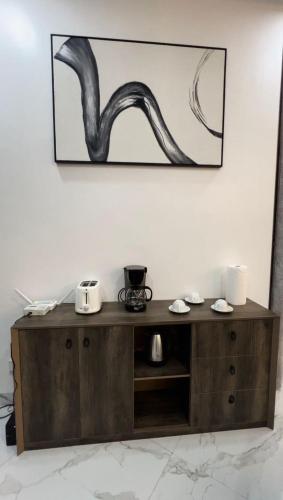 a wooden cabinet with a painting on the wall at Keylah Guest House in Cotonou