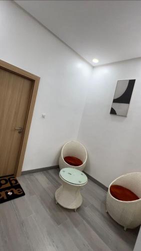 a room with two chairs and a table and a door at Keylah Guest House in Cotonou