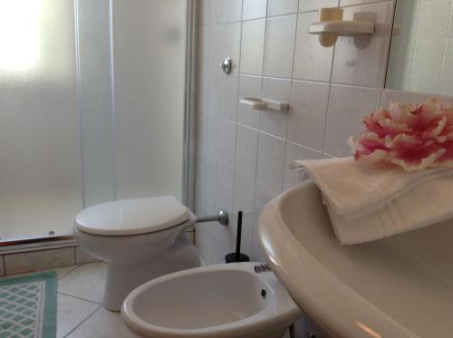 a white bathroom with a toilet and a sink at B&B Peschici Rooms in Peschici