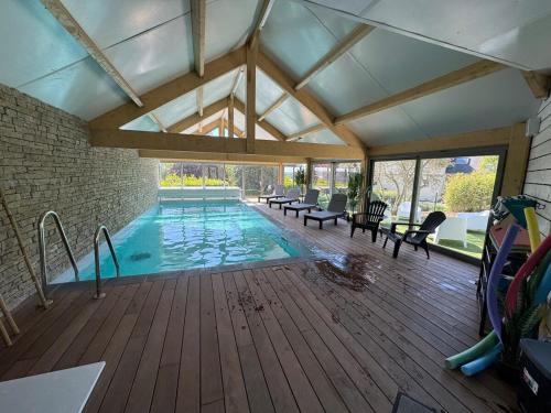 - une piscine dans un bâtiment avec une terrasse en bois dans l'établissement Le Panoramique, à Barneville-Carteret