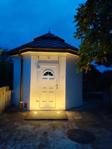a small white building with a white door at Single Tiny House Salzkammergut in Regau