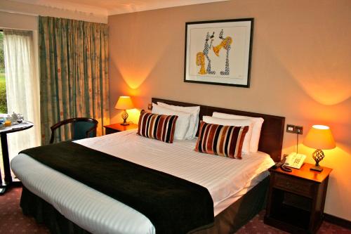 a bedroom with a bed with two lamps and a phone at Ellington Lodge at The Concorde in Eastleigh