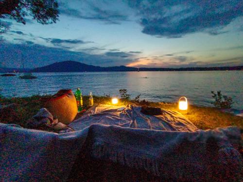 a table with two candles on the shore of a lake at Single Tiny House Salzkammergut in Regau