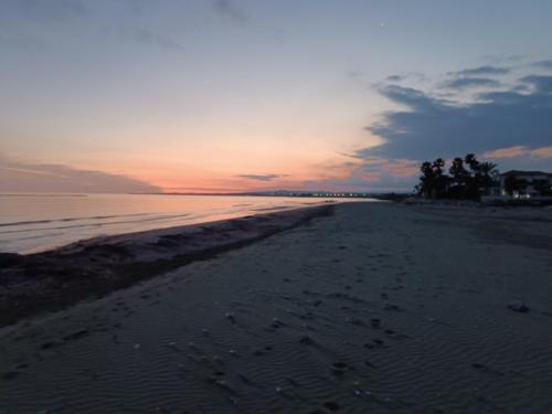 a view of the beach at sunset at Blue Aura Beach villa Larnaca in Pervolia