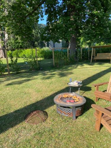 a firepit in a yard with a bench and a tree at Tiny home in Grade 1 listed church garden in Dunham