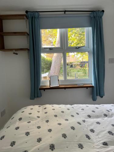a bedroom with a bed and a window at Tiny home in Grade 1 listed church garden in Dunham