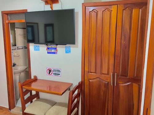 a room with a table and a television on a wall at Hotel Camino Nacional Salento in Salento