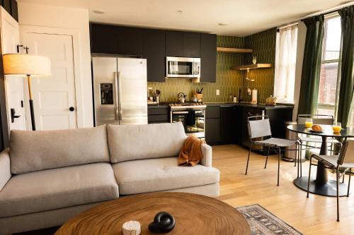 a living room with a couch and a kitchen at Sosuite at The Jefferson - Fishtown in Philadelphia