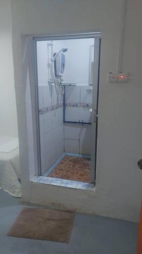 a shower with a glass door in a bathroom at Pandan Hotel in Papar