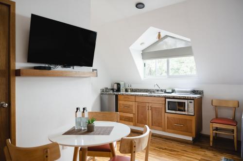 a kitchen with a table and a small kitchen with a tv at The Gallery in Mexico City