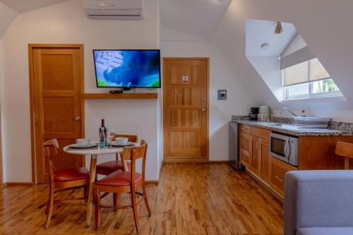 a kitchen with a table and a tv on the wall at The Gallery in Mexico City