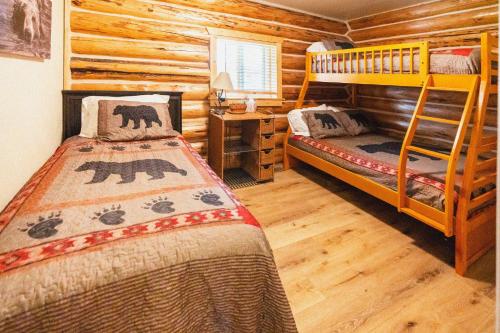 a bedroom with two bunk beds in a log cabin at Firepit & Outdoor Dining|Sleeps 10|Dogs Welcome in Seeley Lake