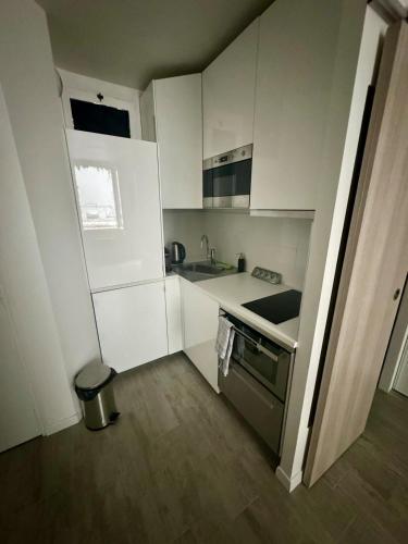 une petite cuisine avec des armoires blanches et un évier dans l'établissement Studio with private terrace Neuilly sur Seine, à Neuilly-sur-Seine