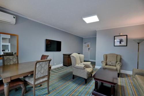 a living room with a dining room table and chairs at Holiday Inn - Bulawayo by IHG in Bulawayo