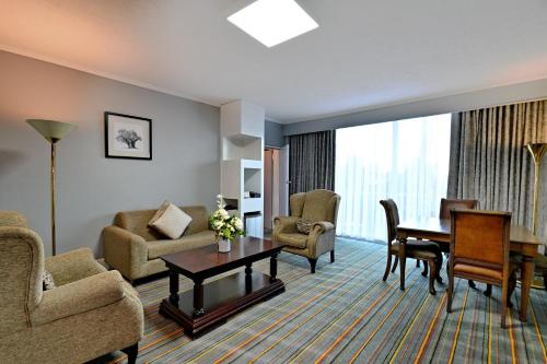 a room with a living room with a table and chairs at Holiday Inn - Bulawayo by IHG in Bulawayo