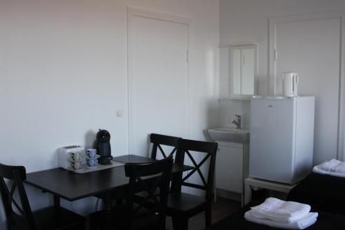 a kitchen with a table and chairs and a refrigerator at The Castle in Búðardalur