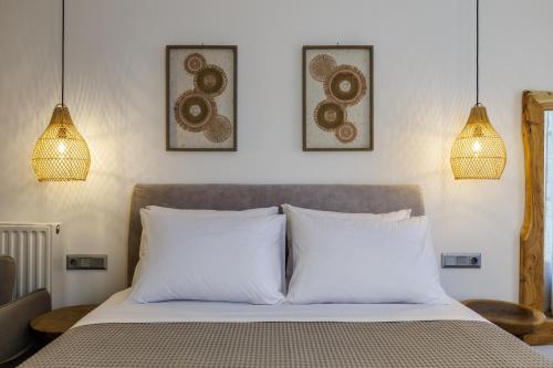 a bedroom with a bed with three pictures on the wall at Skopelos Prime Central Stays in Skopelos Town