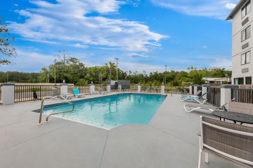 a swimming pool on a balcony with patio furniture at Spark By Hilton Biloxi Ocean Springs in Biloxi