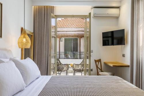 a hotel room with a bed and a balcony at Skopelos Prime Central Stays in Skopelos Town