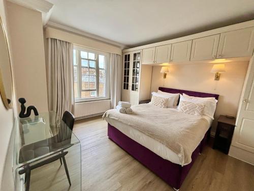 a bedroom with a large bed and a glass table at The Mozart Suite by Sloane Square in London