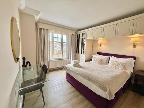 a bedroom with a large bed and a window at The Mozart Suite by Sloane Square in London