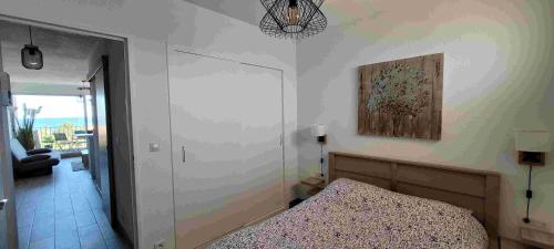 une chambre avec un lit et un tableau au mur dans l'établissement Face à la Mer, à Saint Cyprien Plage