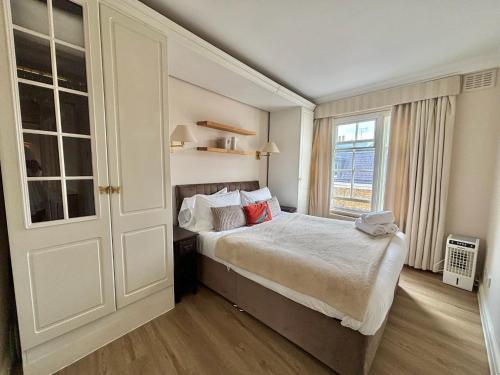 a bedroom with a large bed and a window at The Mozart Suite by Sloane Square in London
