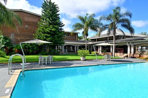 a swimming pool in front of a house at Holiday Inn - Bulawayo by IHG in Bulawayo