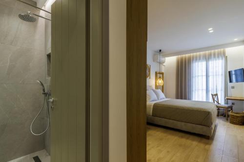 a bedroom with a bed and a bathroom with a shower at Skopelos Prime Central Stays in Skopelos Town