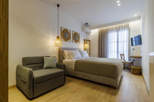 a bedroom with a bed and a couch and a chair at Skopelos Prime Central Stays in Skopelos Town