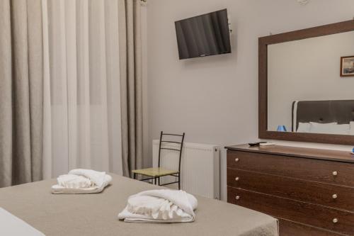 a bedroom with a bed and a dresser with a mirror at Dionysis Elegant Cozy Apartment in Filiatra