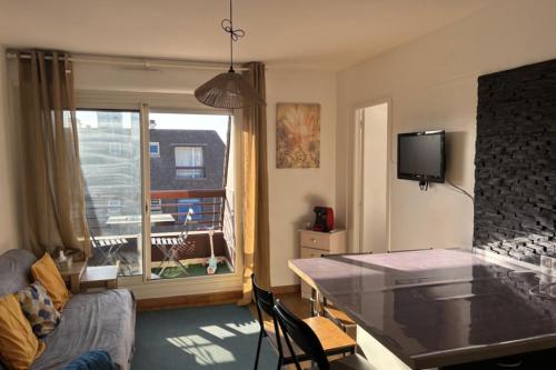 un salon avec une table et un canapé dans l'établissement Superb flat with sea views, à Houlgate