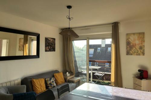 un salon avec un canapé et une grande fenêtre dans l'établissement Superb flat with sea views, à Houlgate