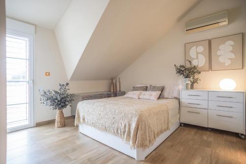 a white bedroom with a bed and a dresser at Holiday Villa Benmar in Castellón de la Plana