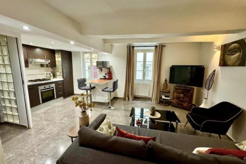 un salon avec un canapé, une télévision et une table dans l'établissement Bright apartment in the heart of Hyères, à Hyères
